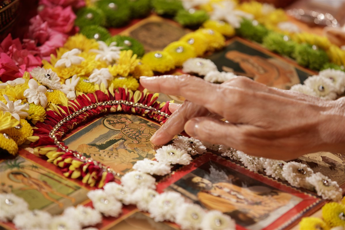 Swamishri touches the feet of the murtis in his puja