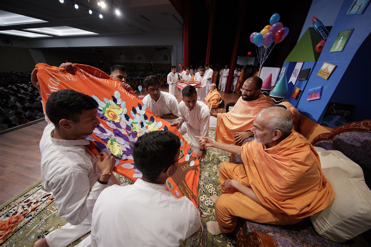 Swamishri is offered a shawl by youths