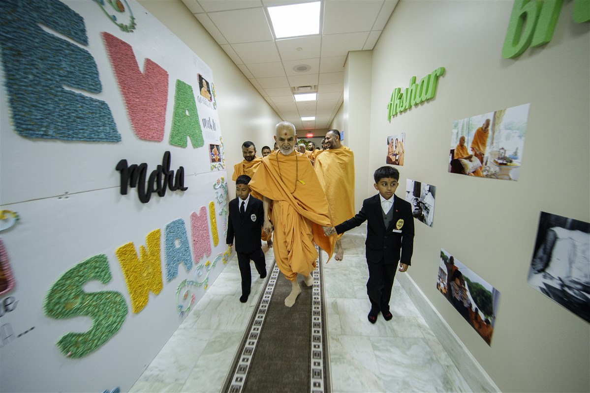 Swamishri walks with children dressed as security guards