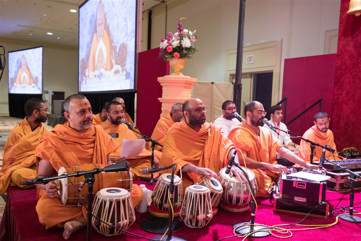 Swamis sing kirtans during Swamishri's puja