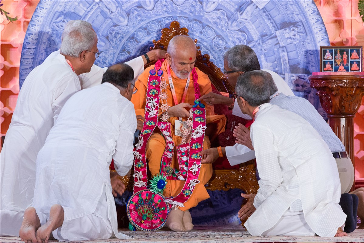 Devotees garland Swamishri