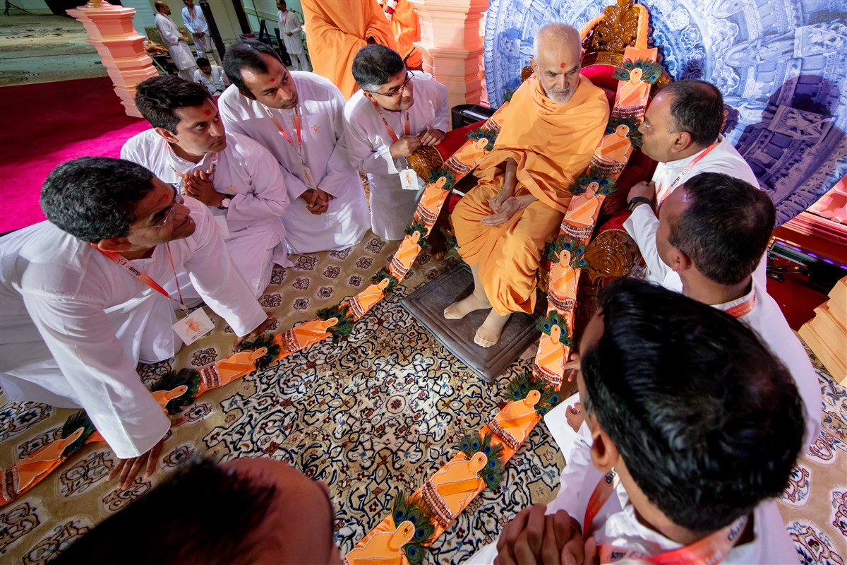 Devotees garland Swamishri