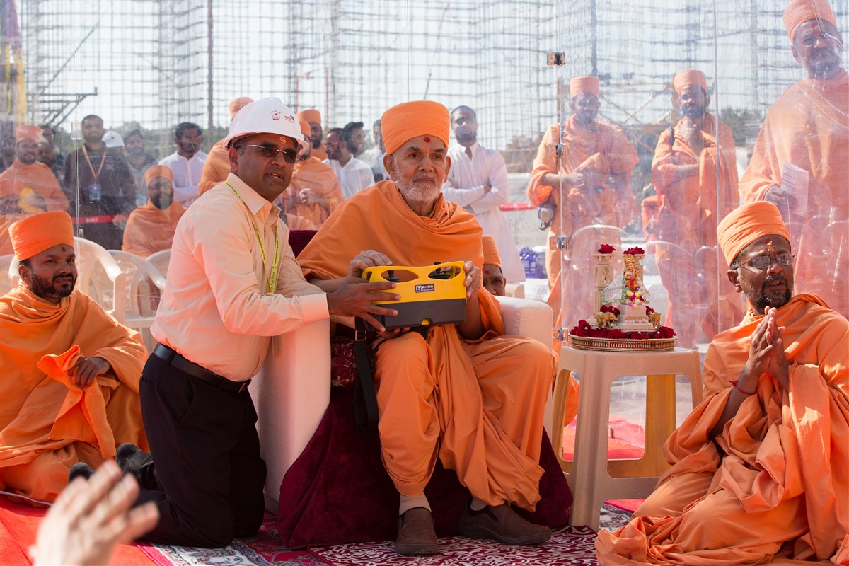 Swamishri operates the crane to install the first pillar of Swaminarayan Akshardham