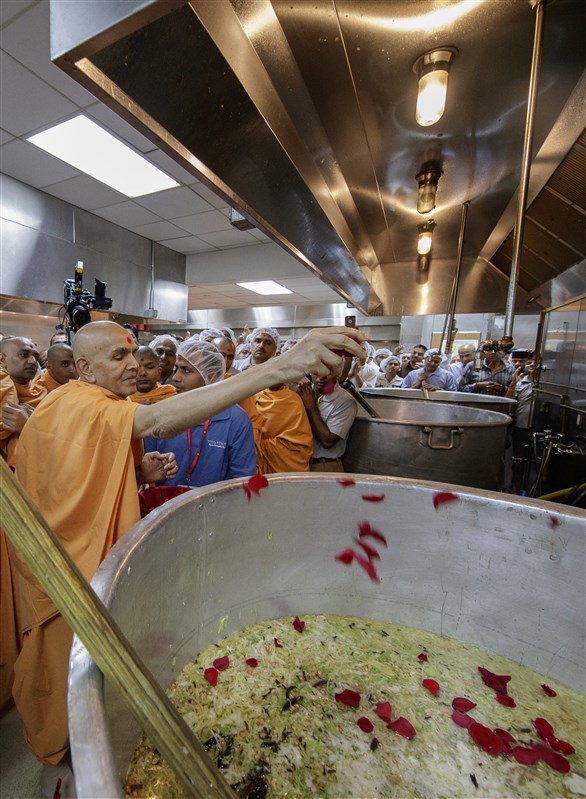 Swamishri sanctifies khichdi which was served to the devotees during HH Pramukh Swami Maharaj's Asthipushpa Visarjan later in the evening