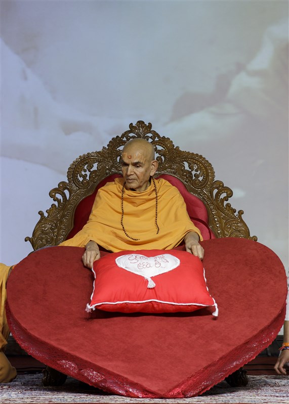 Youths present Swamishri with a pillow with 'youths are my heart' written on it
