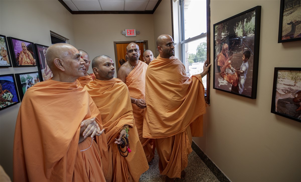 Swamishri views a photo of Pramukh Swami Maharaj interacting with children
