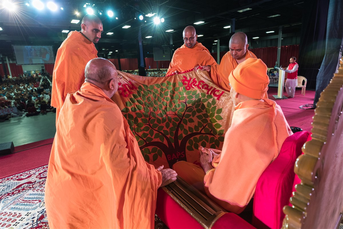 Swamishri is offered a shawl by Swamis
