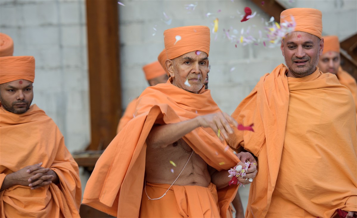 Swamishri showers flowers on the construction site