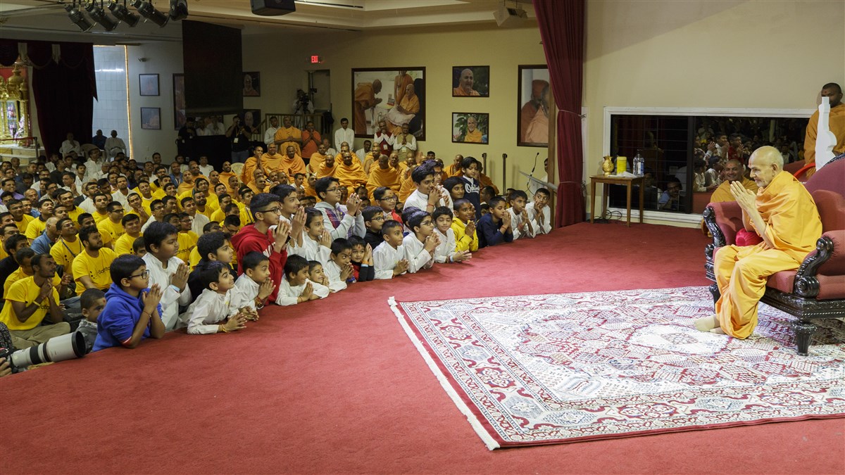 Swamishri greets the children in the audience with folded hands