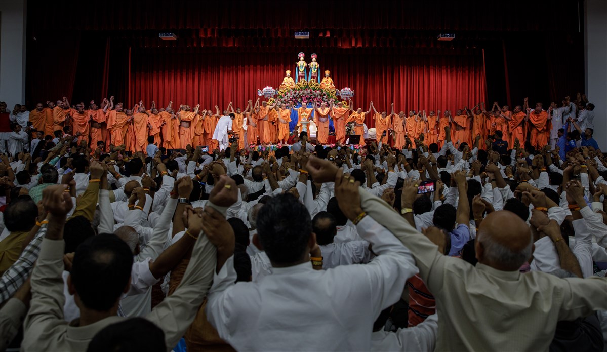 Swamishri joins hands with Swamis and devotees in a gesture of unity