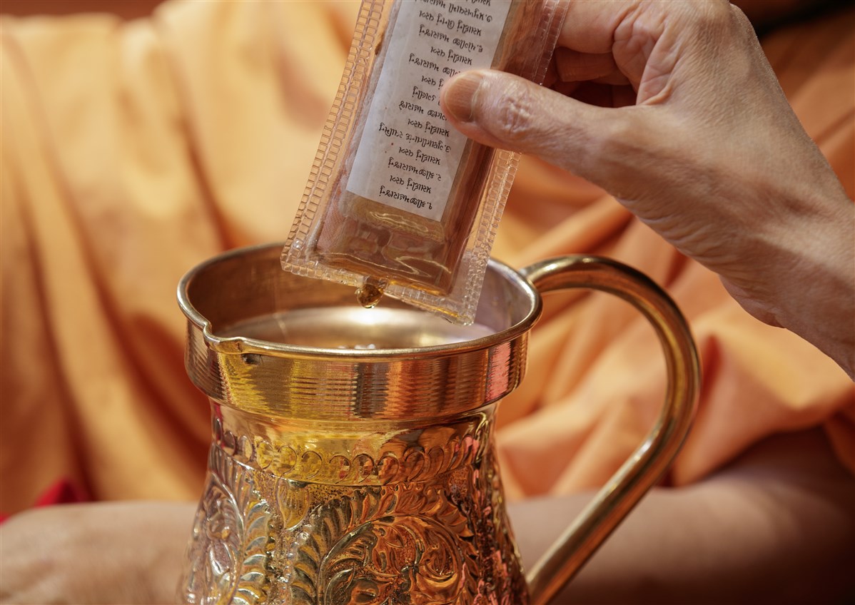 Swamishri sanctifies water with holy relics of Bhagwan Swaminarayan and the Guru Parampara
