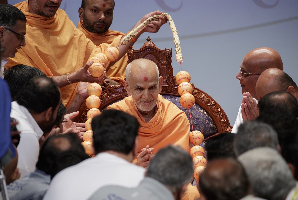 Swamishri is garlanded with a unique garland made of balls with names of BAPS Swamis
