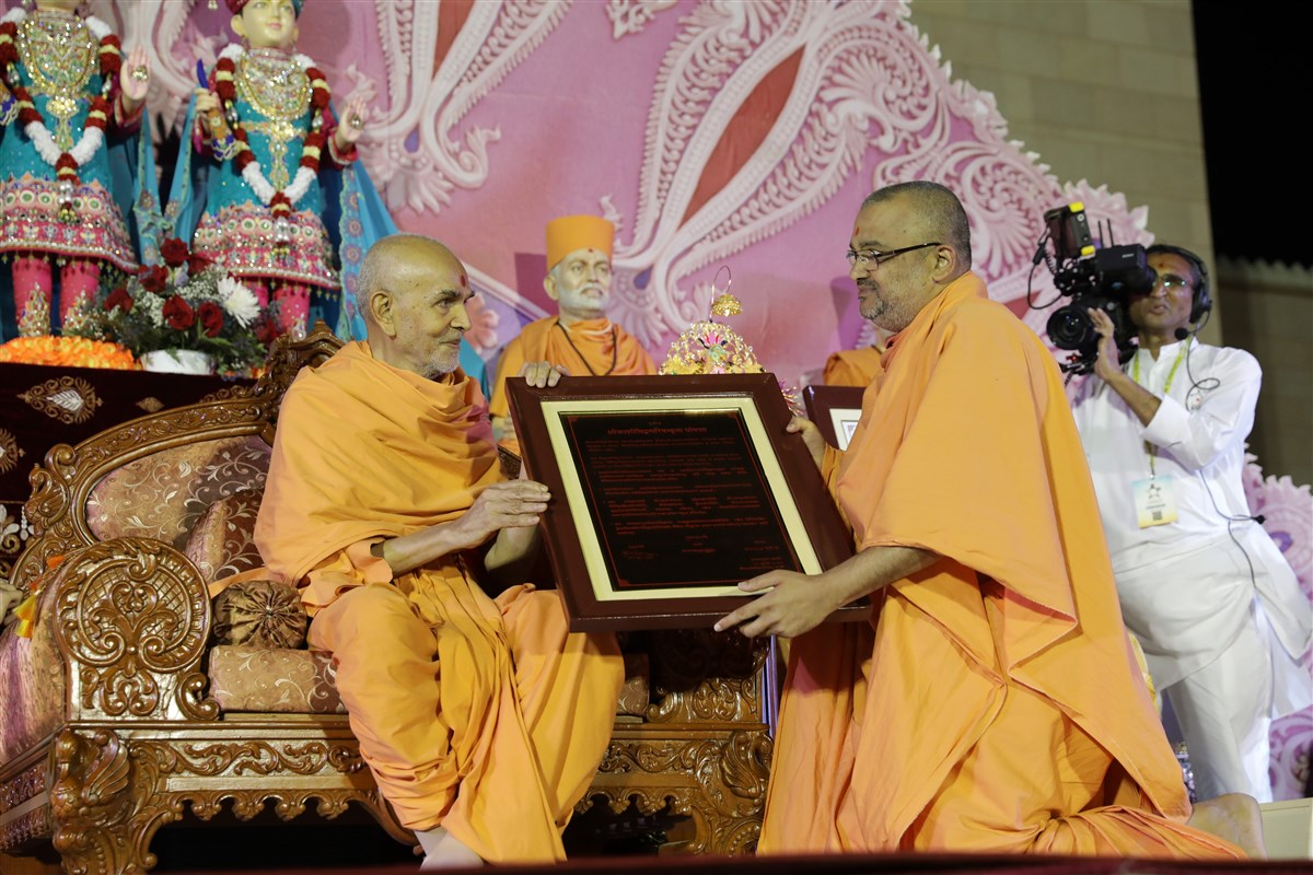 Swamishri sanctifies the Svāminārāyaṇasiddhāntasudhā recognition letter given by the Śrī Kāśī Vidvat Pariṣad to Mahāmahopādyāya Pujya Bhadreshdas Swami