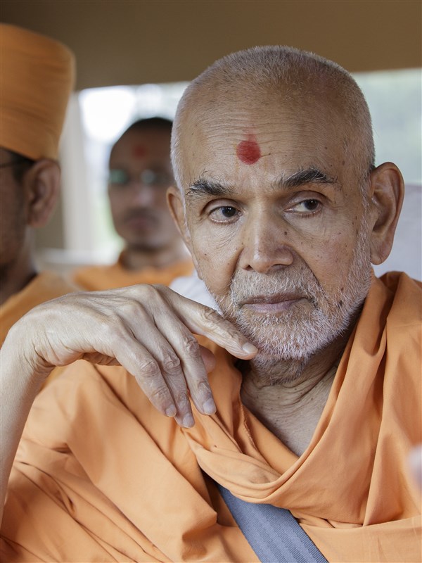 Swamishri attentively listens to details of the Swaminarayan Akshardham campus