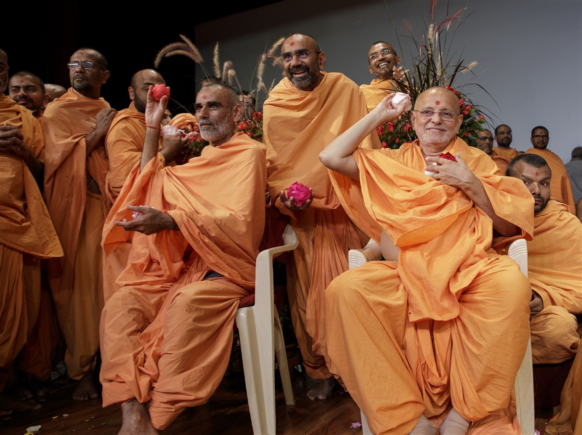 Senior Swamis shower devotees with flower petals
