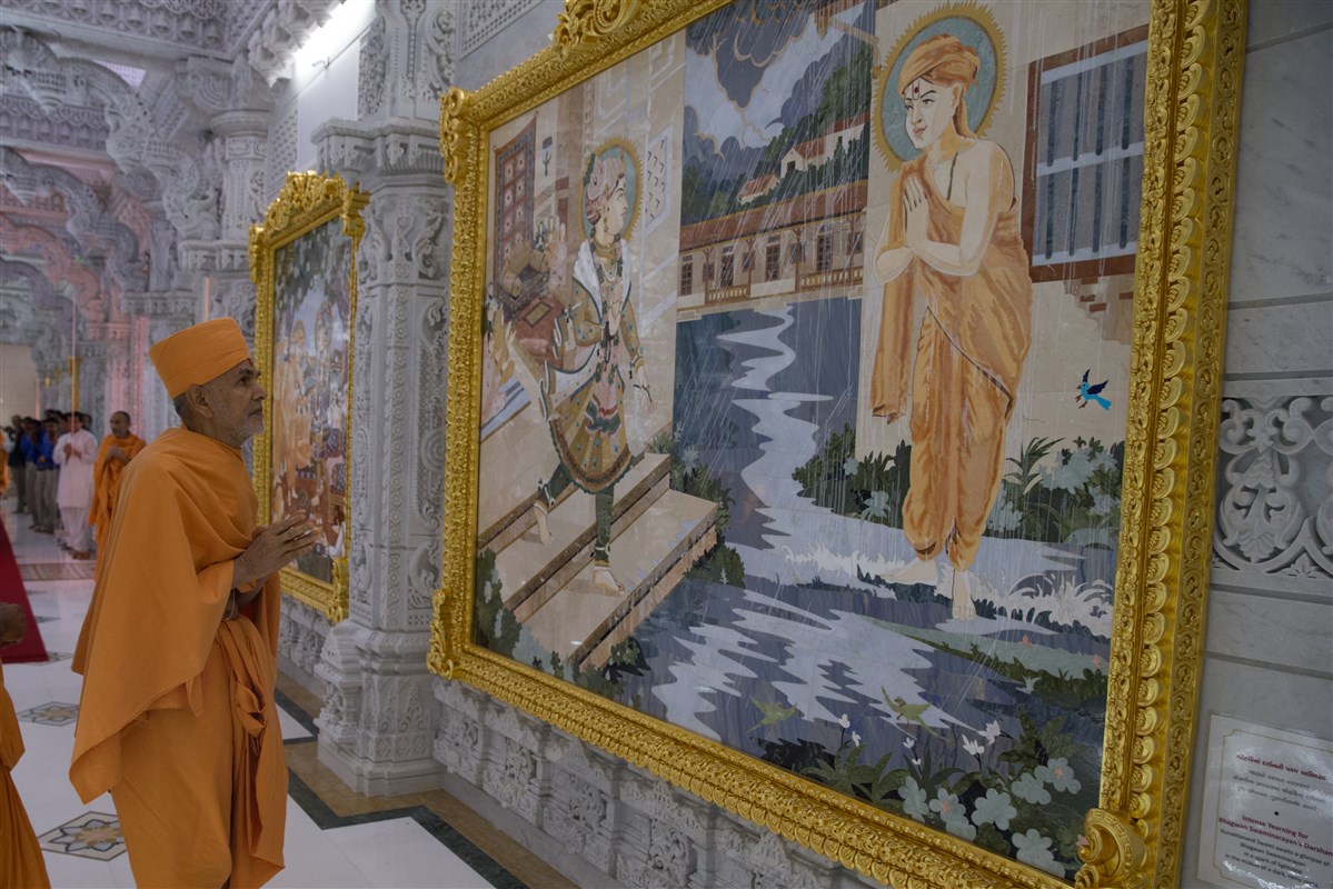Swamishri observes murals around the Mandir
