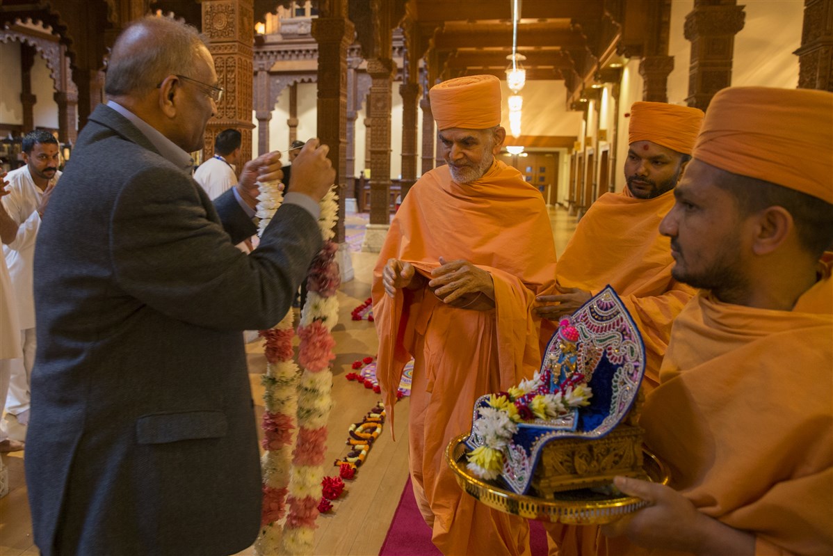 Param Pujya Mahant Swami Maharaj arrives with Shri Harikrishna Maharaj at BAPS Shri Swaminarayan Mandir, London and is greeted by a trustee