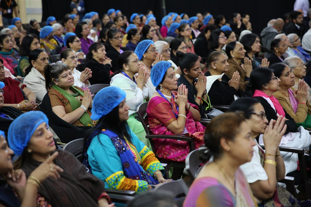 Many devotees and volunteers sat in the gymnasium...