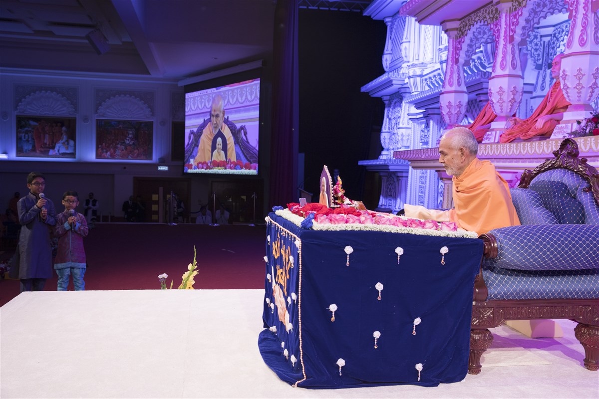 Children recite lofty excerpts from the scriptures during Swamishri's puja