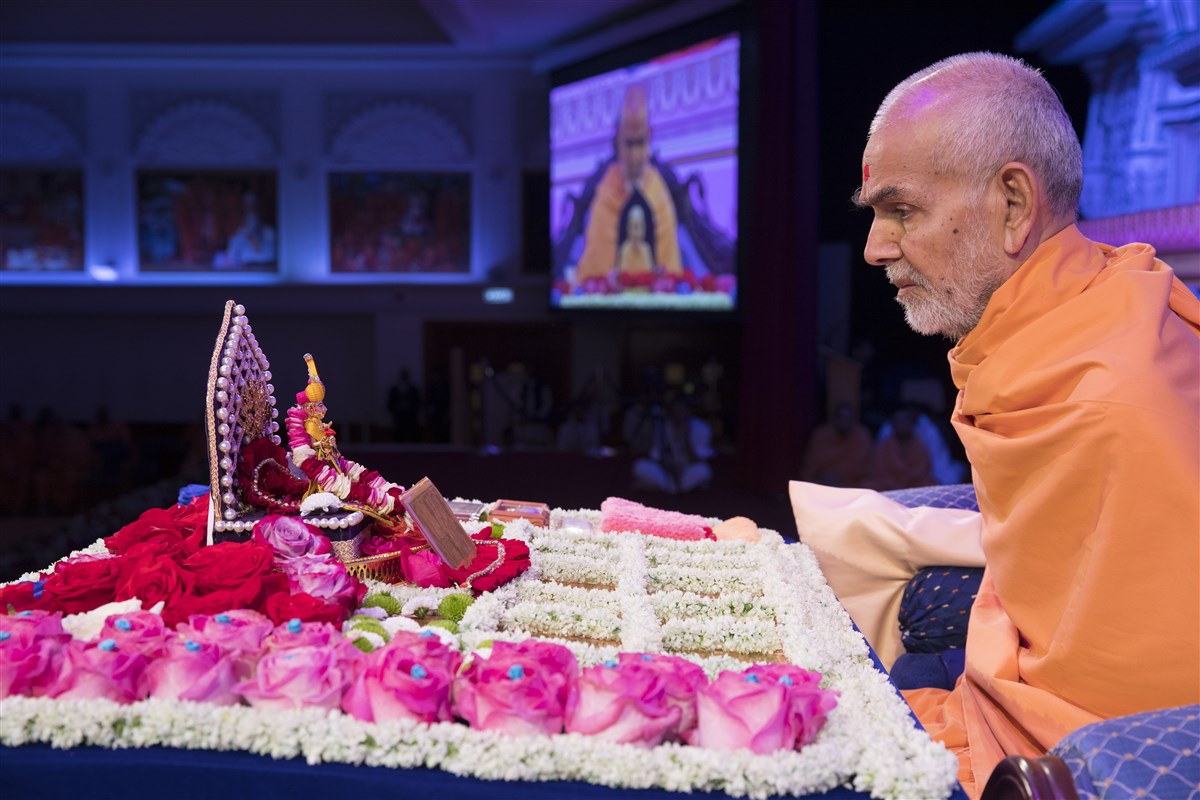 Swamishri engrossed in chanting the 'Swaminarayan' mahamantra with his mala