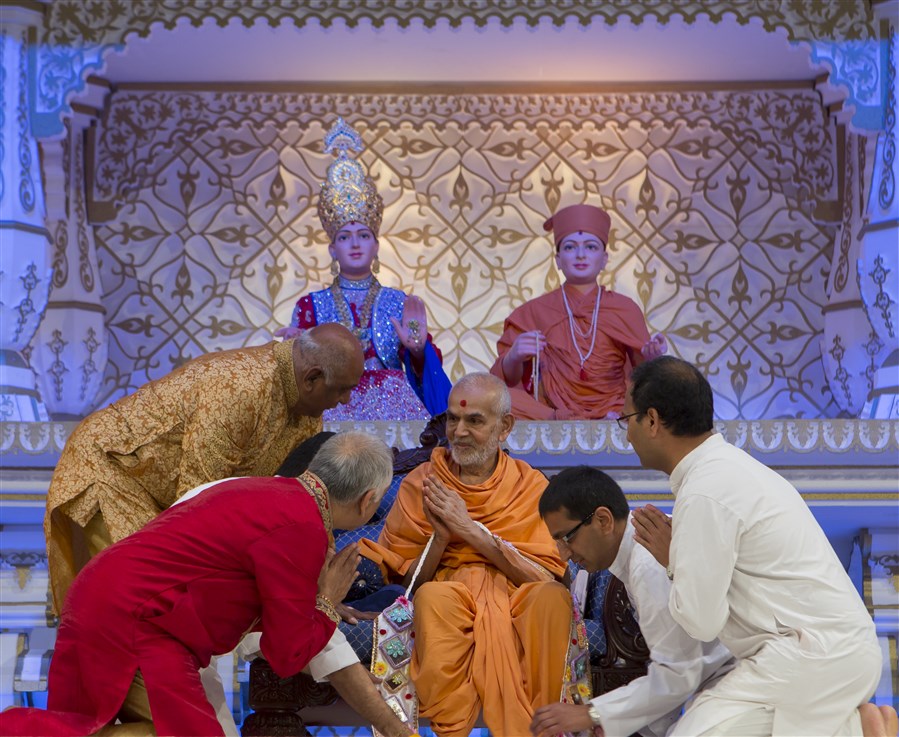 Lead volunteers of East London Satsang Mandal honour Swamishri with a decorative garland