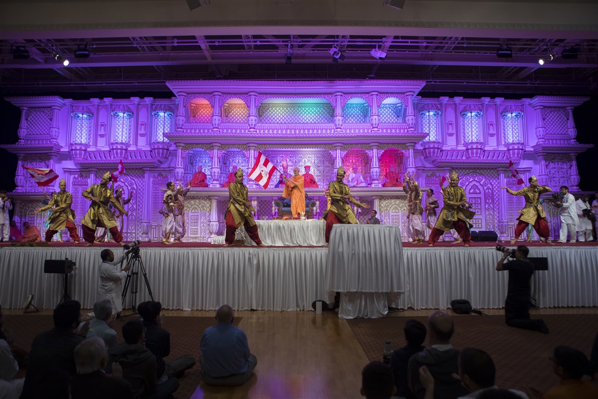 Children and youths of East London perform a dance before Swamishri