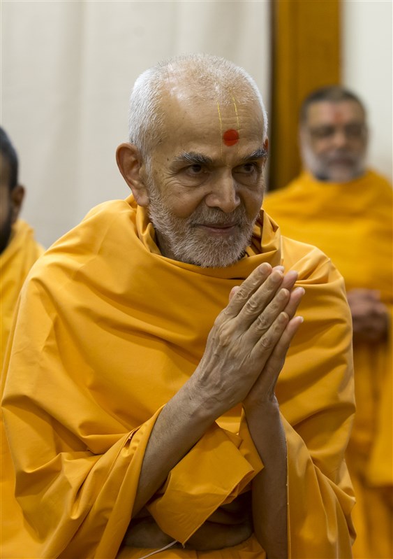 Swamishri greets devotees with folded hands after his puja