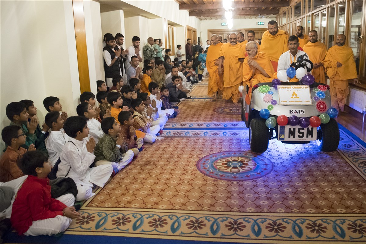 Swamishri greets children on his way to the hall