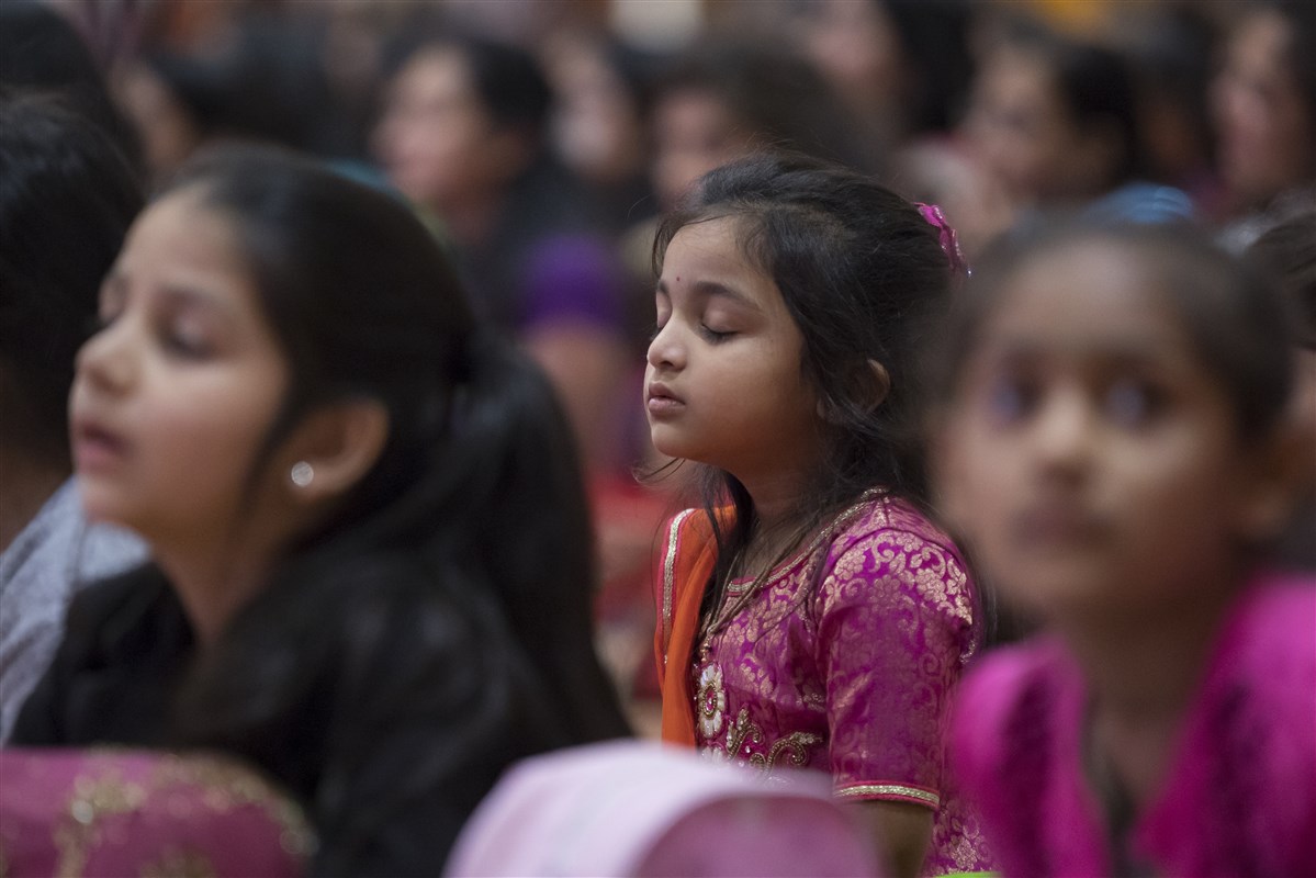 Children engrossed in Swamishri's puja