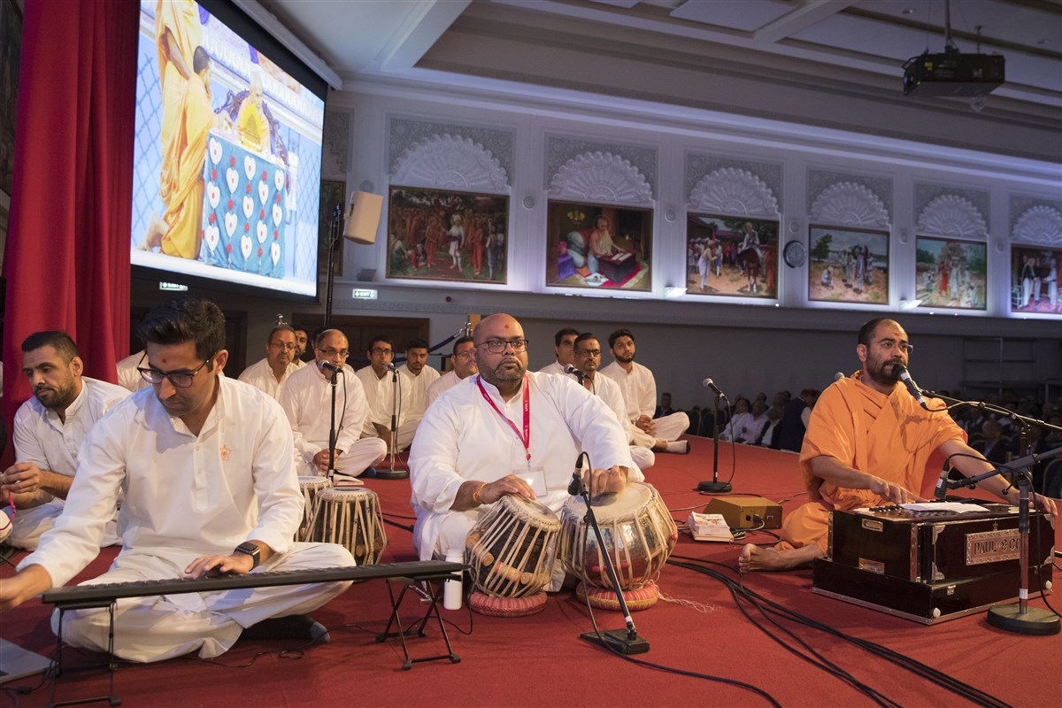 Swamis and yuvaks sing kirtans in Swamishri's puja