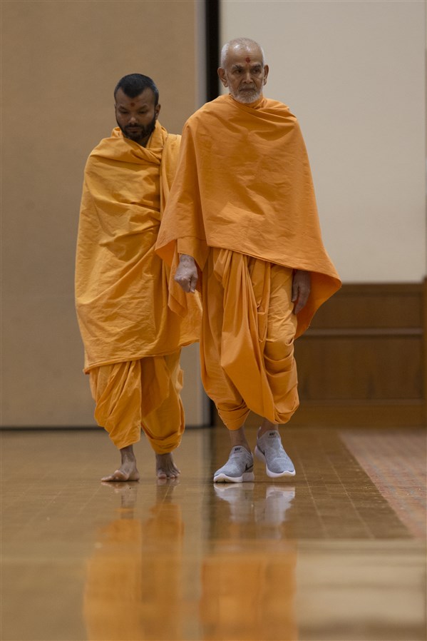 Swamishri performs his afternoon walk in the assembly hall