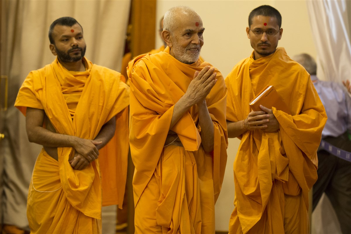 Param Pujya Mahant Swami Maharaj emerges from his room with folded hands