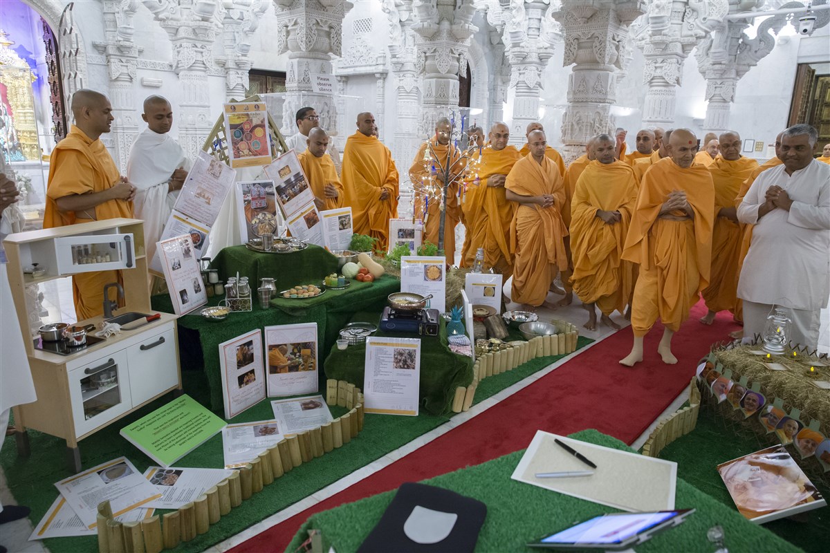 Swamishri observes with interest a thematic display prepared by the mahila devotees