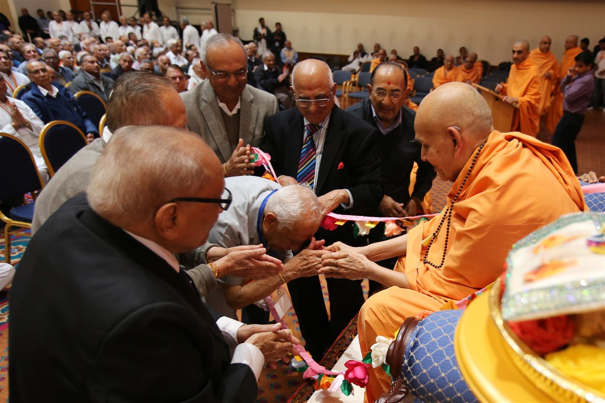 Swamishri is honoured by senior devotees