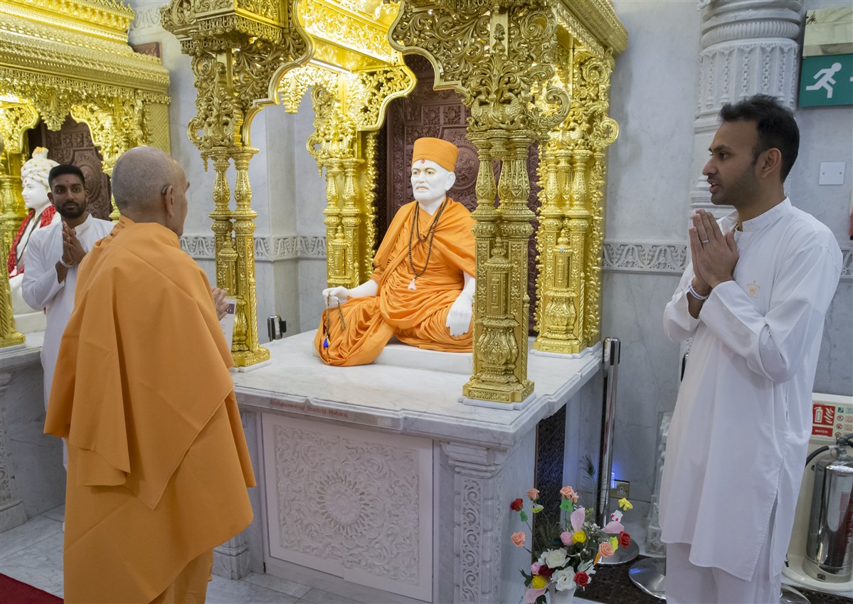 Swamishri engrossed in the darshan of the Guru Parampara, as yuvaks present on today's theme for Yuvak-Yuvati Din