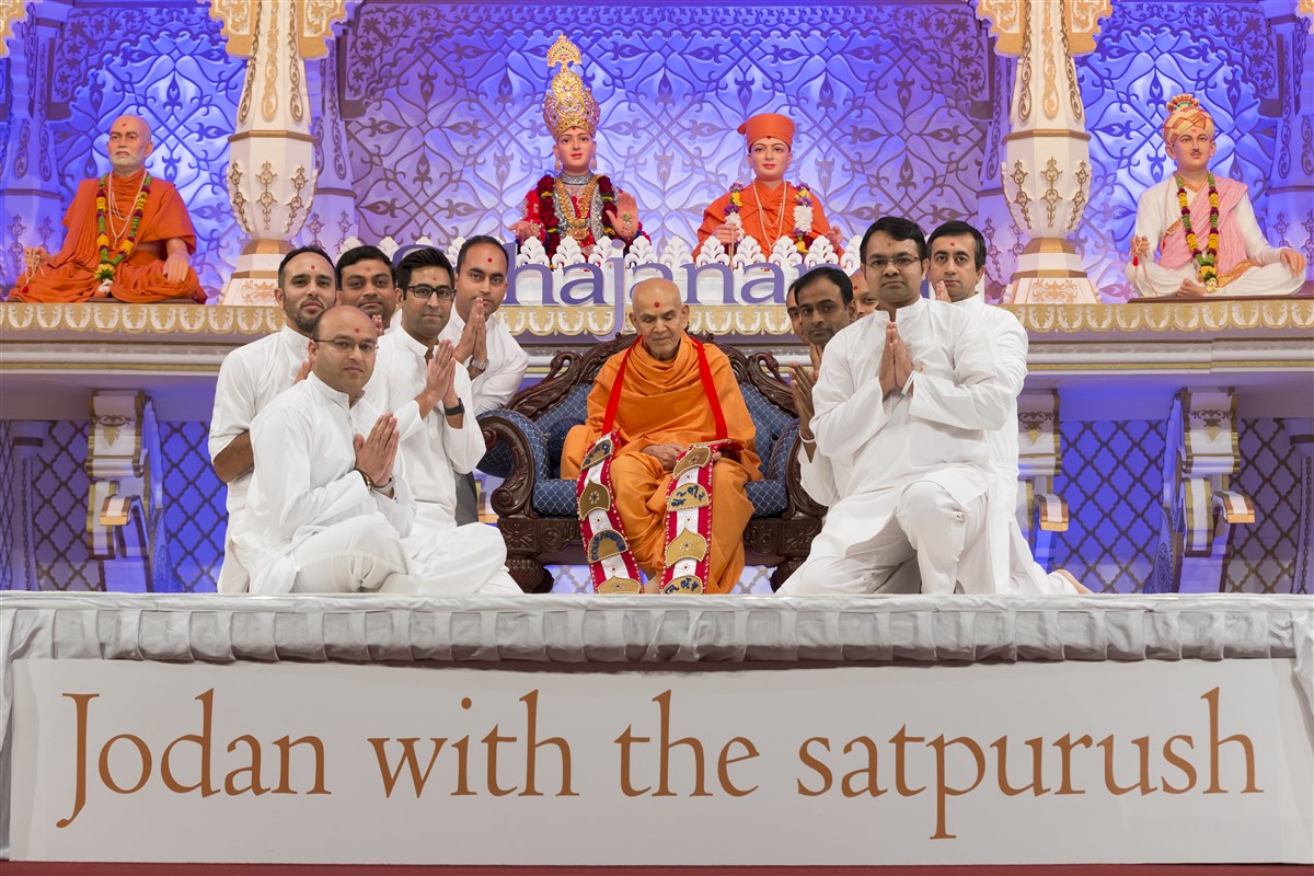 Volunteers honour Swamishri with a decorative garland