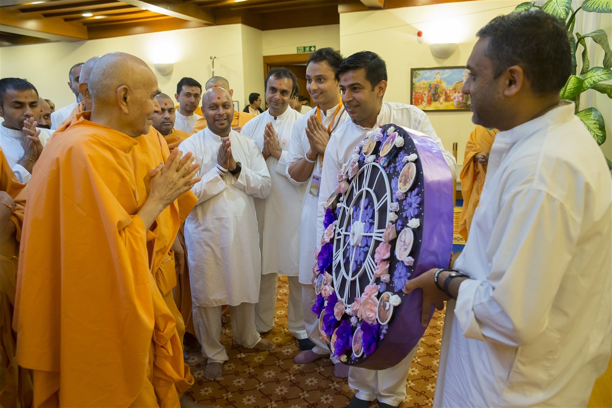 Volunteers present Swamishri with a floral clock