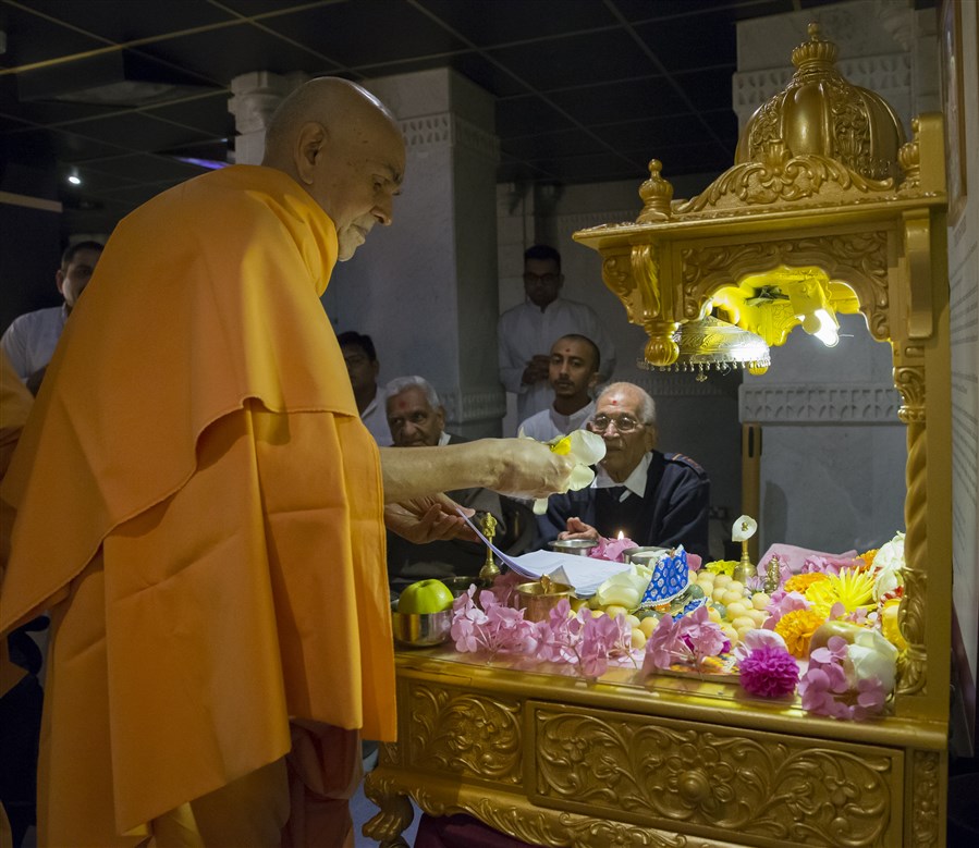 Swamishri offers flowers to the mahapuja