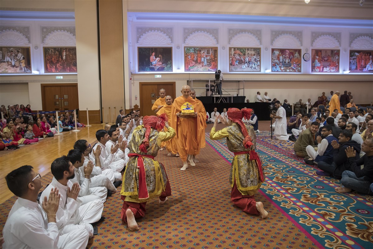 Swamishri enters the assembly hall with Shri Harikrishna Maharaj to a vibrant dance