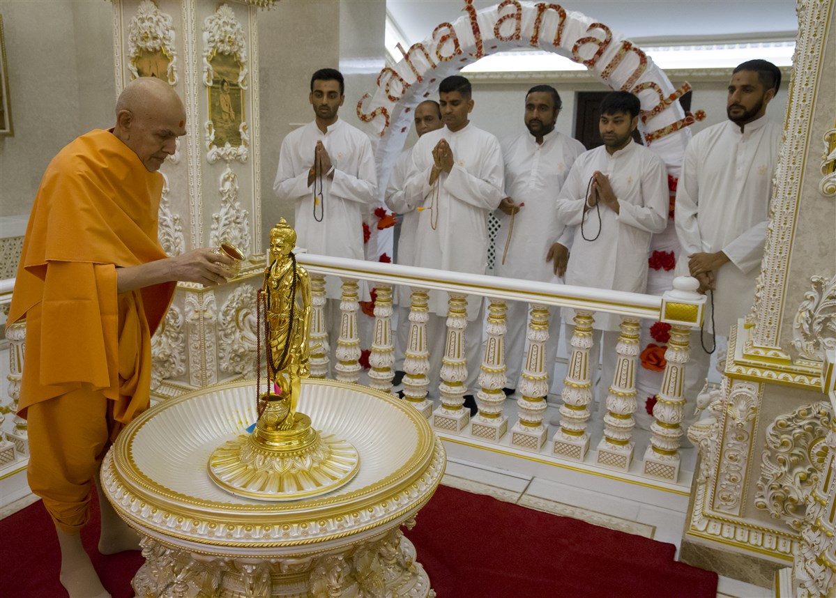 Swamishri performs the abhishek of Shri Nilkanth Varni, as yuvaks chant the Swaminarayan mahamantra