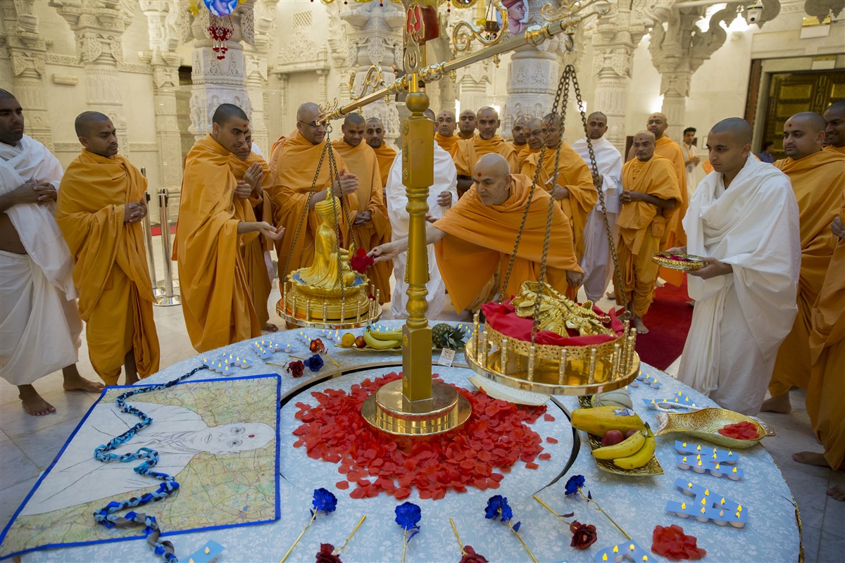 Swamishri offers flowers to the murti of Bhagwan Swaminarayan