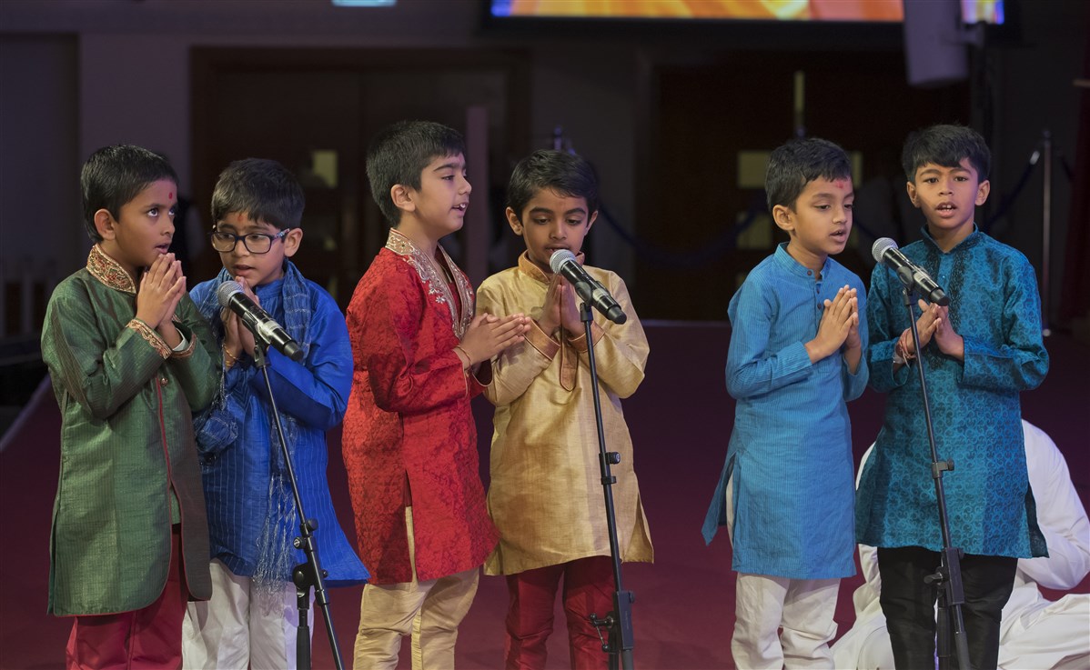 Children present scriptural passages in Swamishri's puja