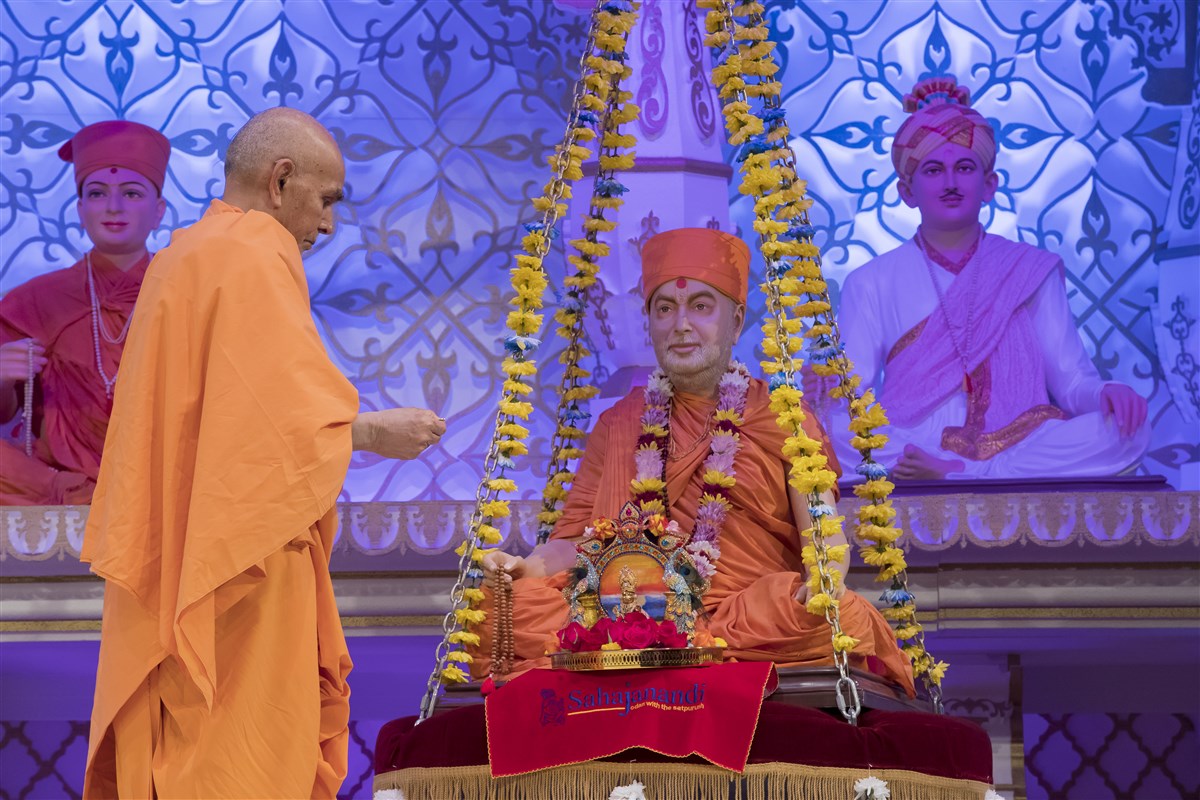 Swamishri engaged in the guru pujan of Pramukh Swami Maharaj