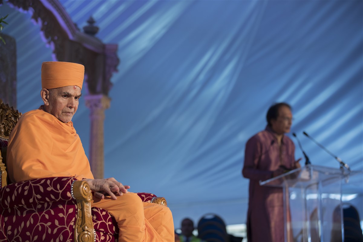 Swamishri listens intently as a volunteer retraces the history of Satsang in East London