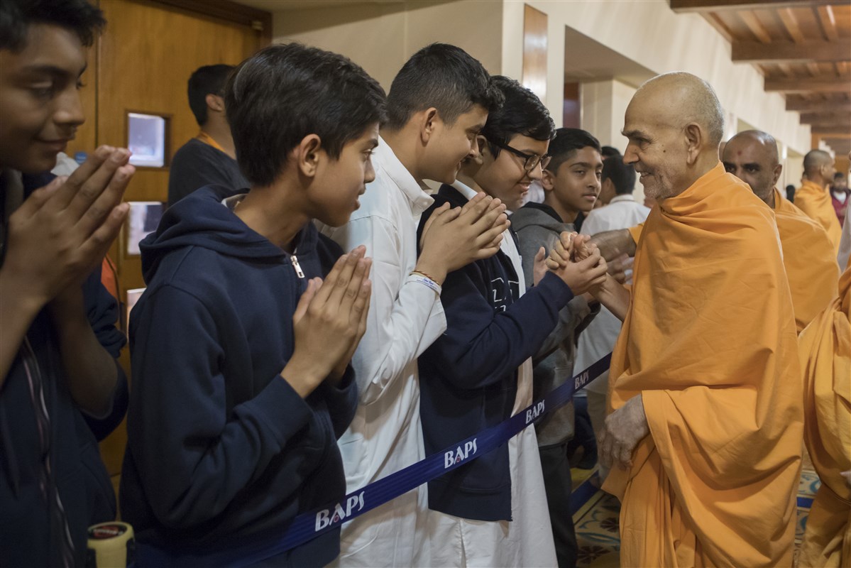 Swamishri blesses children on his way from the assembly hall
