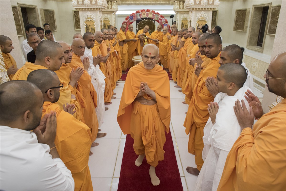 Swamishri greets everyone with folded hands, ensuring he misses no one