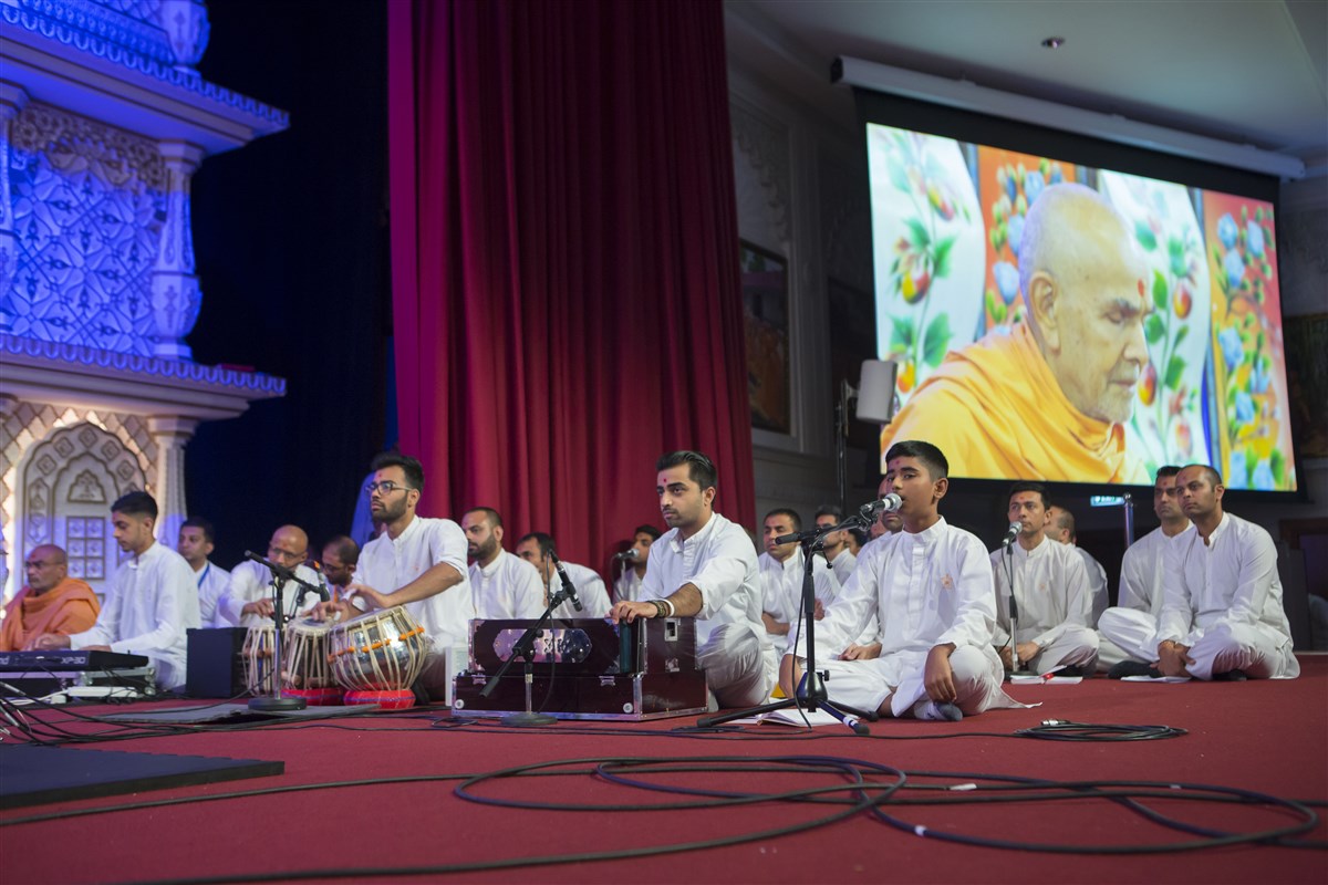 A balak sings in Swamishri's puja