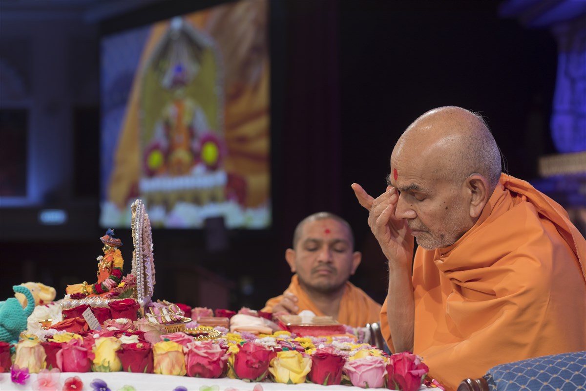 Swamishri offers his respects to the murtis in his puja