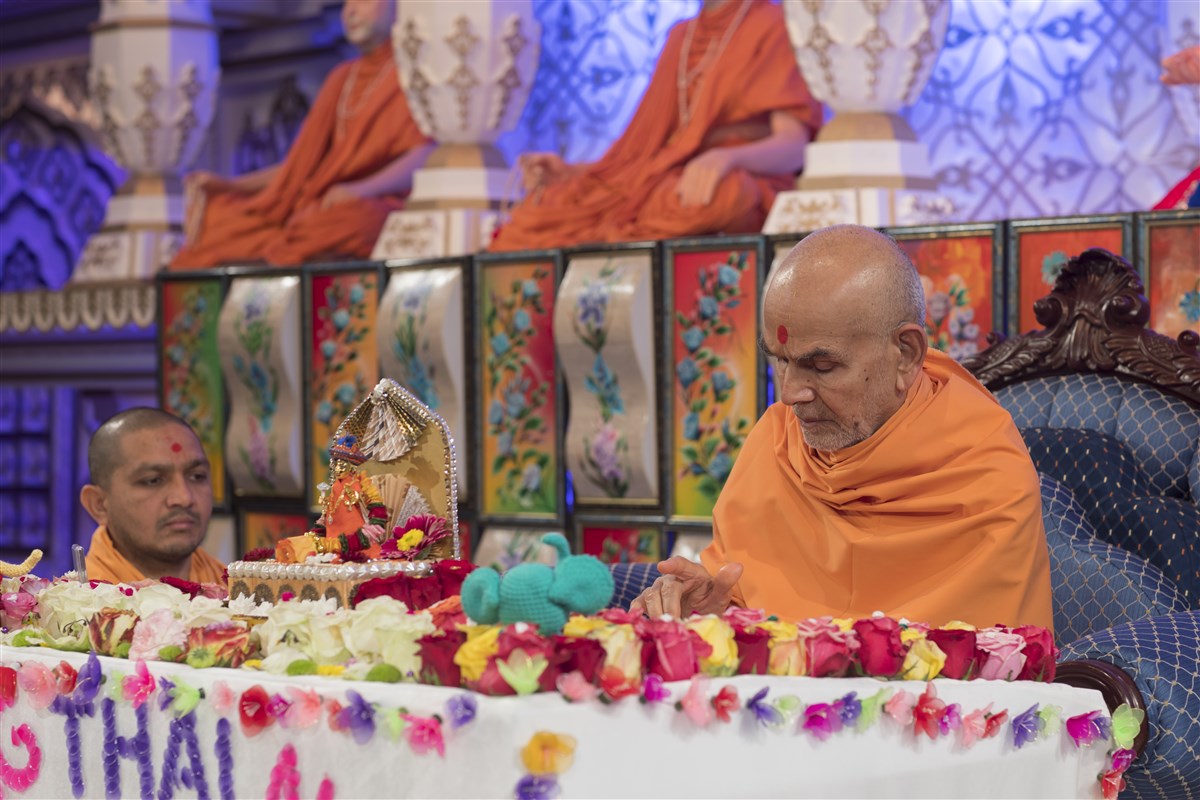 Swamishri offers his respects to the murtis in his puja
