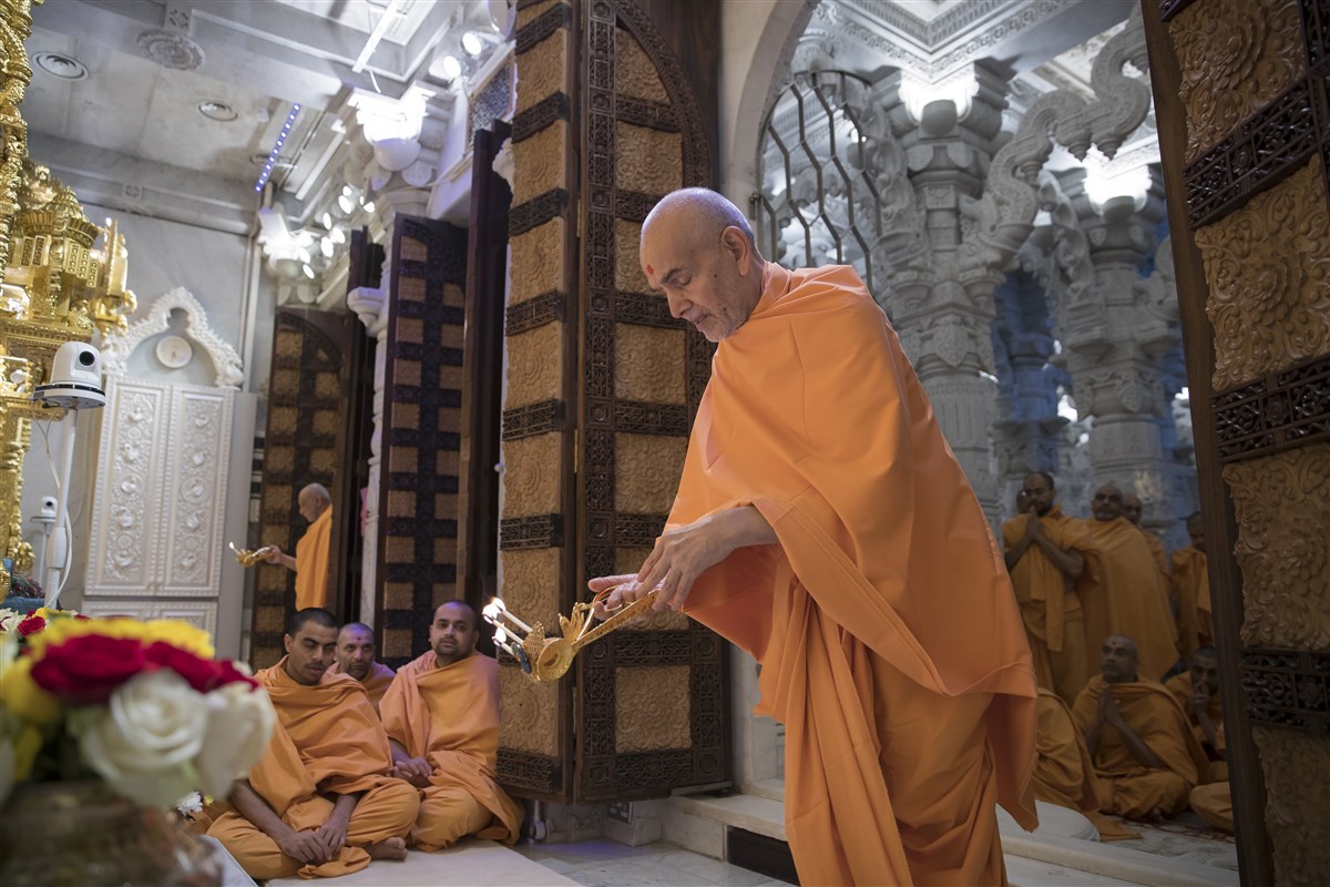 Swamishri performing the arti of the central shrine murtis